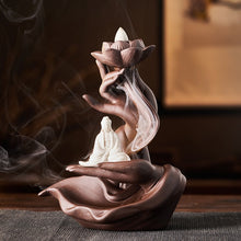 Load image into Gallery viewer, Thunderbolt Spiritual Books Back Flow Incense Burner on a table with Incense burning. A peaceful Kuan Yin sits in one of the hands in the mudra.
